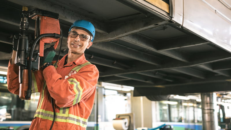 A smiling CMBC worker in safety gear