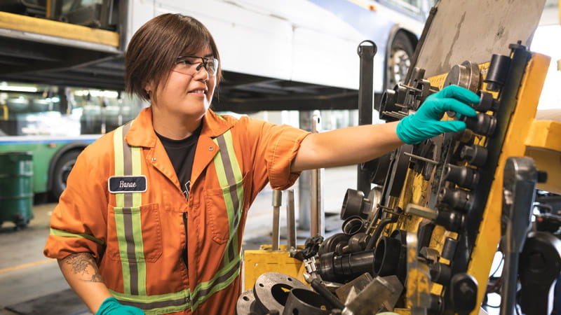 A mechanic at Coast Mountain Bus Company touching maintenance equipment