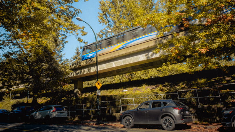 SkyTrain passing along BC Parkway path on Vanness Ave in autumn