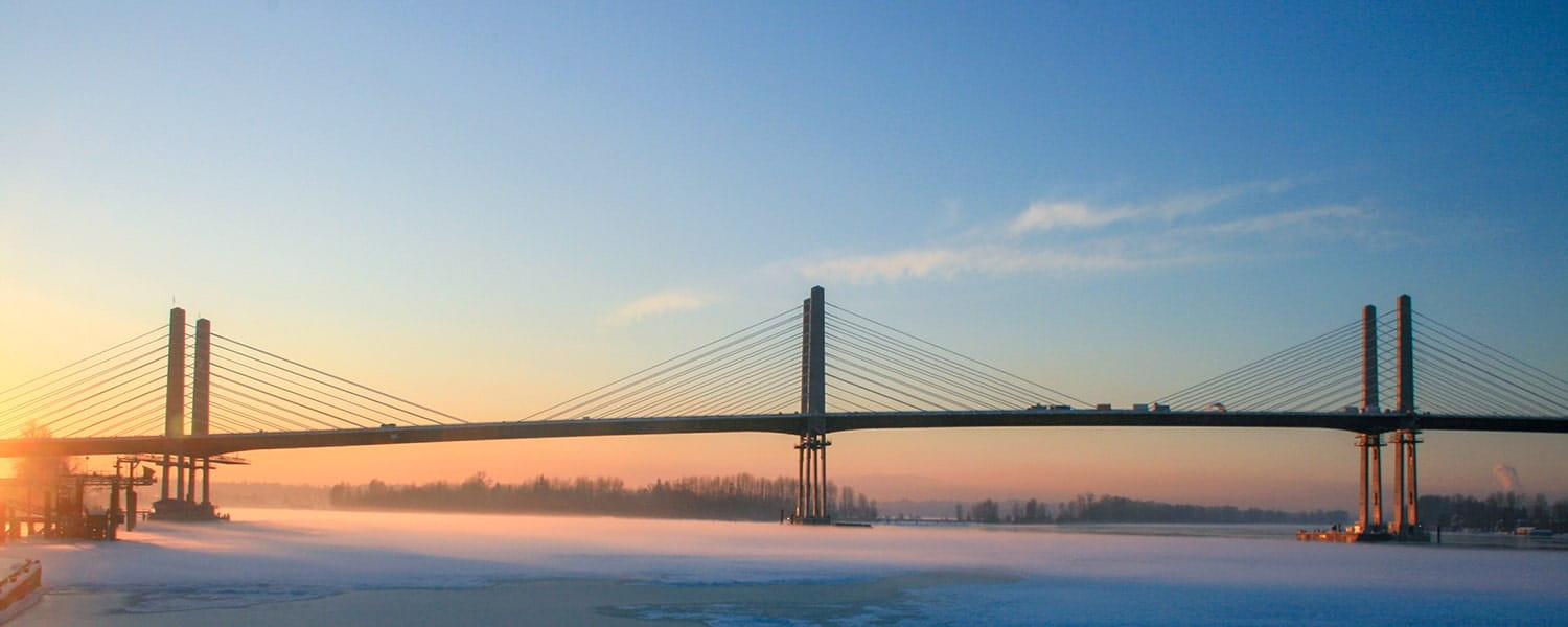 A view of Golden Ears Bridge with the sun rising in the background