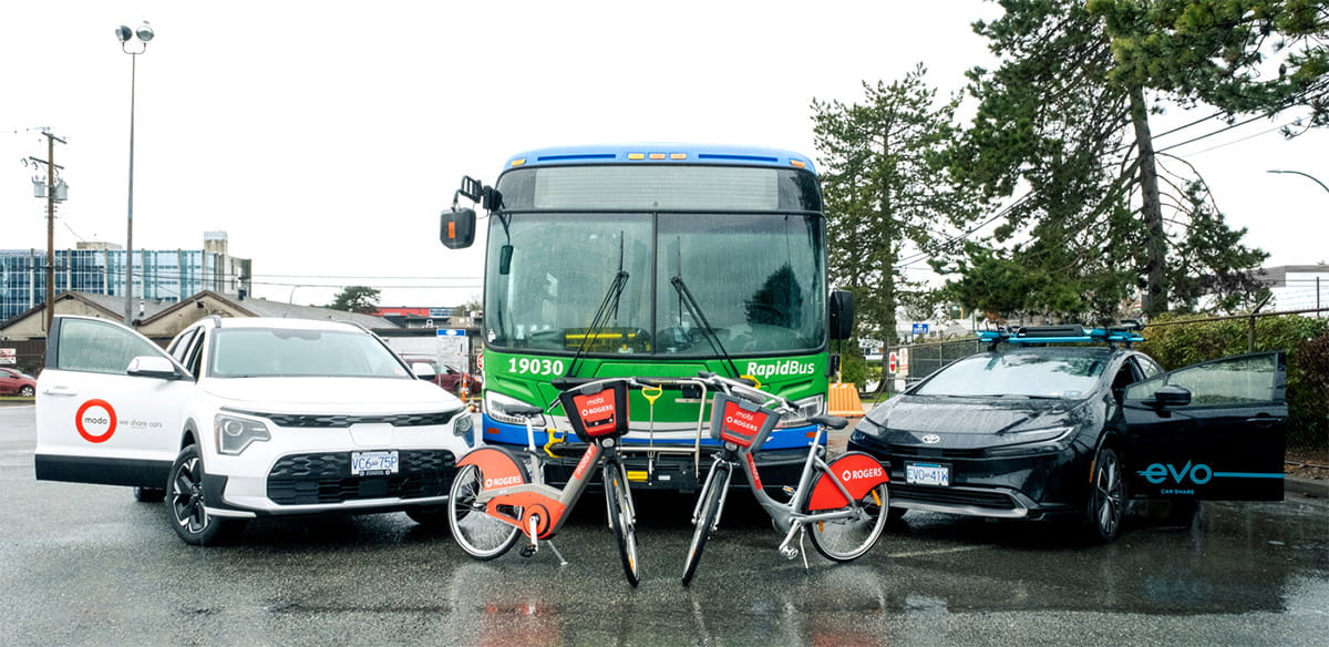 An Evo vehicle, Mobi e-bike and Modo vehicle, parked in front of a green RapidBus.